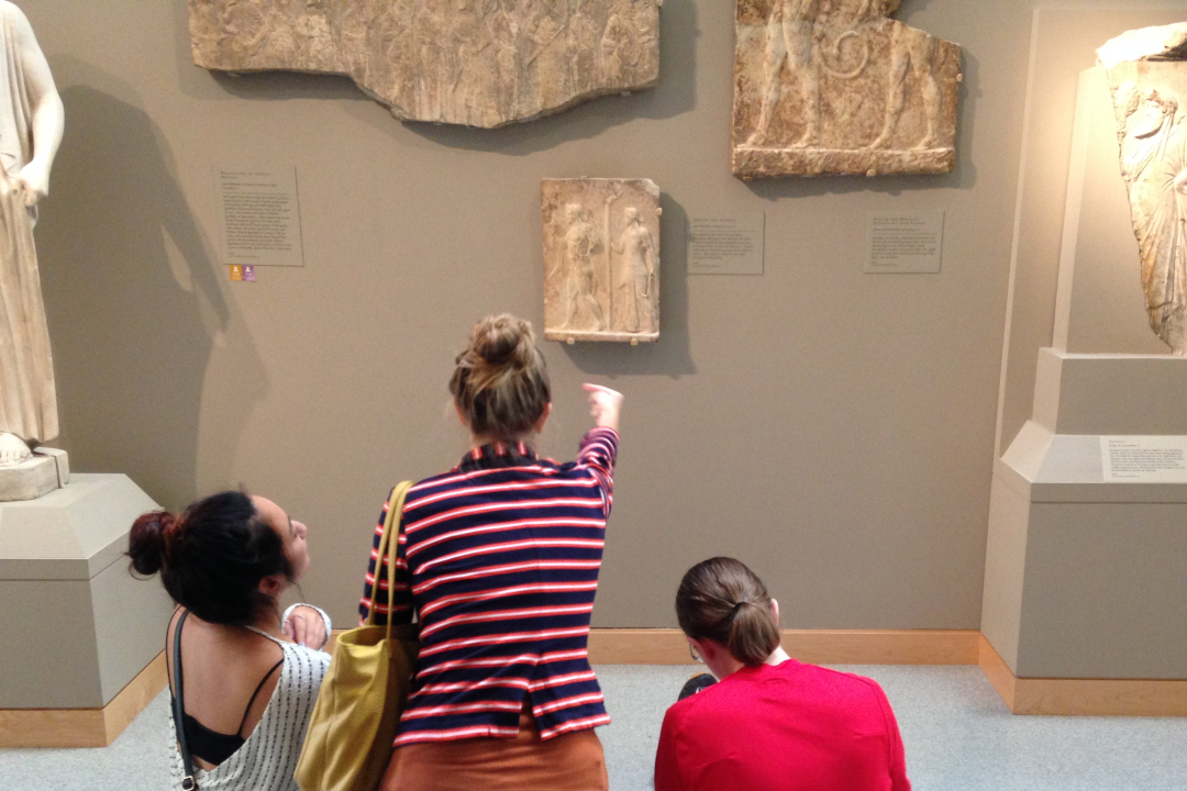 Photo Header, shows students studying stone carving in a museum
